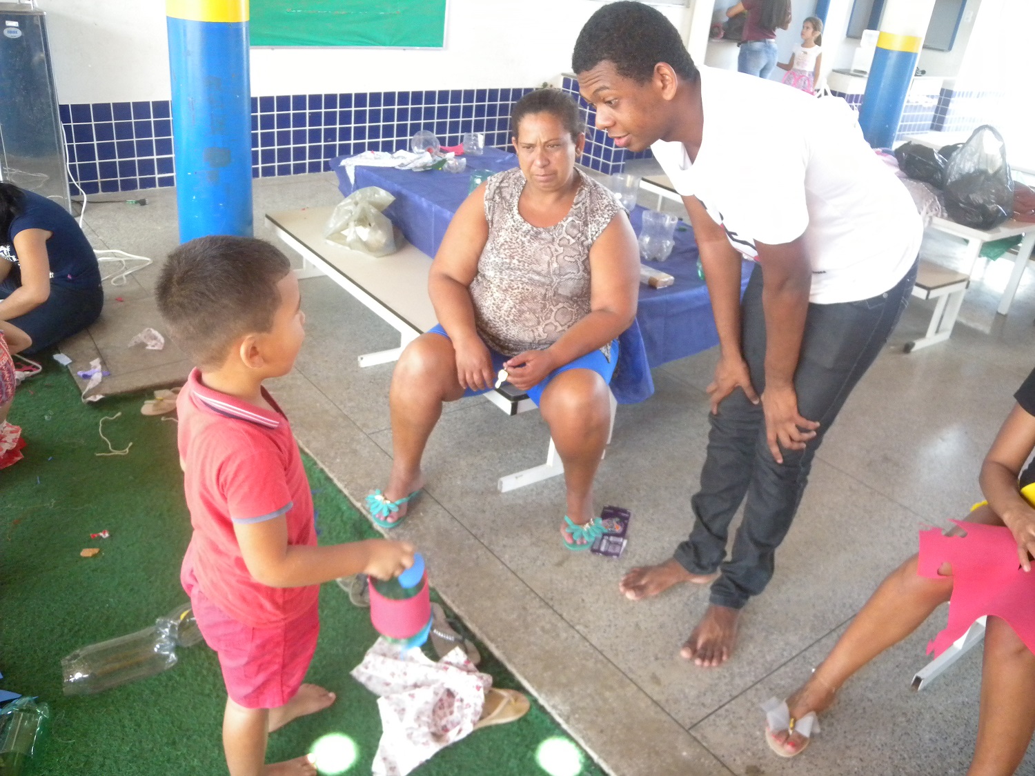 "Cola agora não. Vamos desenhar?", convida o estudante de Terapia Ocupacional , Lucas Santos, o pequeno Igor Samuel, 3, sob o olhar da avó, Eliene Martins dos Santos(Foto: Ascom UFS Lagarto)